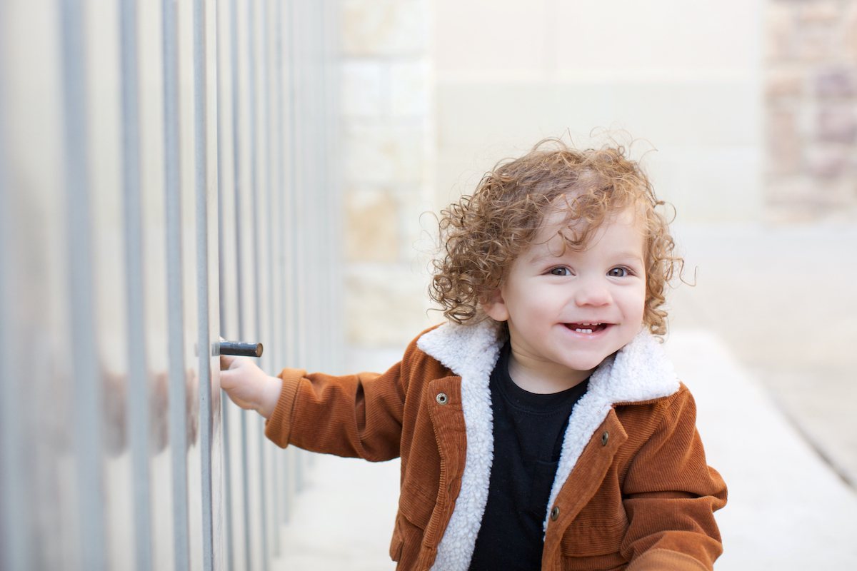 1 year old posing in a brown sherpa jacket